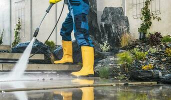 Männer Druck Waschen seine Garten architektonisch Beton Elemente foto