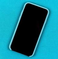 Smartphone im aquablauen Fall auf einem trendigen Aquahintergrund mit Platz für Text foto