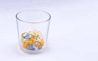 Dosis der farbigen Pillen im Glas foto
