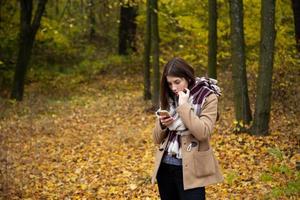 süßes Mädchen in einer braunen Jacke im Herbstwald foto