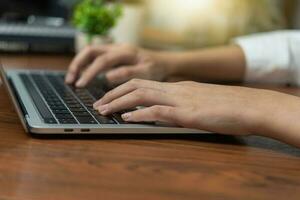 Frau Arbeiten und Tippen auf das Tastatur auf Tabelle beim heim. foto