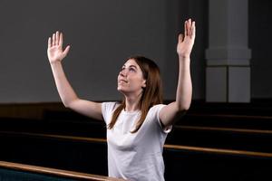 ein christliches Mädchen, das mit demütigem Herzen in der Kirche betet foto