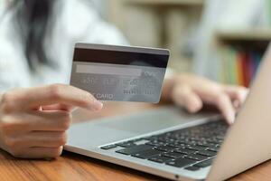 Hand halten Anerkennung Karte und mit Computer online zum Einkaufen oder bezahlen Rechnungen. foto