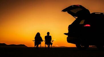 Paar genießen szenisch Sonnenuntergang auf ein Kalifornien Wüste Sitzplätze Nächster zu ihr Fahrzeug foto