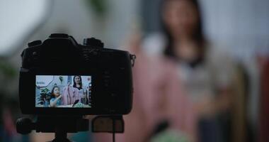 jung schön asiatisch Frau Leben Streaming beim Kleider Geschäft auf Digital Kamera foto