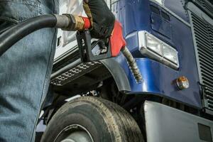 Trucker im Vorderseite von seine LKW vorbereiten zum Diesel Betanken foto