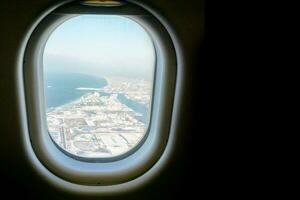 Nahansicht Fenster im das Flugzeug mit Blau und höher von Landschaft Aussicht Hintergrund. foto