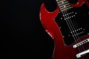 rote E-Gitarren-Nahaufnahme auf schwarzem Hintergrund foto