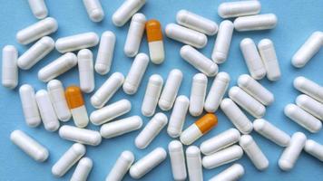 Pille Kapseln auf blauem Hintergrund einfache flache Lage mit Pastell Textur medizinisches Konzept stock photo