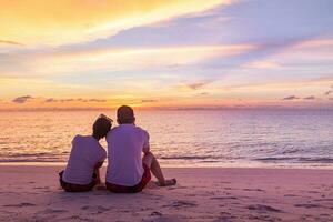 romantisch Paar auf das Strand beim bunt Sonnenuntergang auf Hintergrund. perfekt tropisch Sonnenuntergang Landschaft, exotisch Natur Sicht. glücklich romantisch Paar genießen schön Sonnenuntergang beim das Strand foto