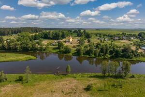 Panorama- Aussicht von ein hoch Höhe von ein mäanderförmig Fluss im das Wald in der Nähe von Dorf foto