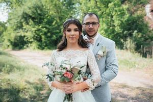 Hochzeitsfoto der Braut und des Bräutigams in einer grau rosa Farbe auf Natur im Wald und in den Felsen foto