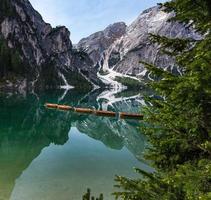 Hochwinkelansicht von Booten mit Mount Searchofel-Spiegelung im klaren, ruhigen Wasser des legendären Pragser Wildsee Lago di Braies in Dolomiten foto