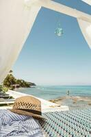 Stroh Hut Lügen auf das Strand Bett mit Glas Dekoration mit Schönheit Aussicht zu das Blau ionisch Meer, klar Himmel und Mädchen im Wasser auf griechisch Insel Zakynthos foto