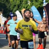 neu delhi, indien - 16. oktober 2022 - vedanta delhi halbmarathonrennen nach covid, bei dem die marathonteilnehmer kurz vor dem überqueren der ziellinie stehen, delhi halbmarathon 2022 foto