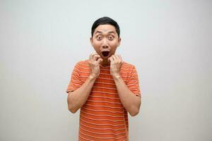 asiatisch Mann Orange Hemd fühlt sich aufgeregt schockiert Gesicht isoliert foto