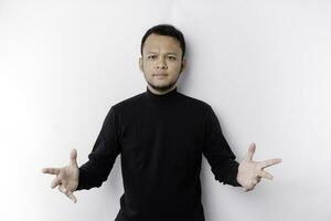 jung asiatisch Mann tragen schwarz T-Shirt präsentieren ein Idee während suchen lächelnd auf isoliert Weiß Hintergrund foto