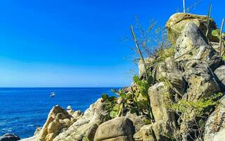 Surfer Wellen Türkis Blau Wasser Felsen Klippen Felsbrocken puerto escondido. foto