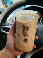 bekasi, Indonesien im März 2023. ein Hand ist halten ein Glas von kopi Kenangan im ein Wagen. foto