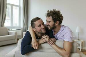 glücklich Fröhlich Paar Lügen Nieder auf das Bett beim heim, umarmen und flirten. lgbt Fröhlich Paar Liebe Momente Glück Konzept foto