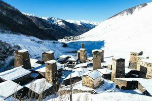 klein Dorf im Winter mit Kaukasus Berg. ushguli berühmt Wahrzeichen im svaneti Georgia ist einer von das höchste Siedlungen im Europa. foto