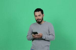 asiatisch Mann Ausdruck während mit Smartphone foto
