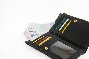 schwarz Brieftasche gefüllt mit fünfzig tausend kolumbianisch Pesos Rechnungen und Karten. Finanzen Konzept. Wirtschaft Konzept. Zahlung Konzept. foto