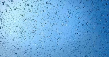 Regentropfen auf blauem Glasfensterhintergrund foto