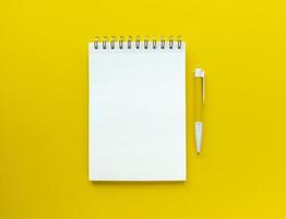 weißes leeres Blatt des Notizbuchs mit Stift auf ihm pädagogischem Konzept in den gelben und weißen Farben stock photo