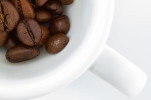 Draufsicht auf eine Kaffeetasse und Kaffeebohnen auf weißem Hintergrund foto