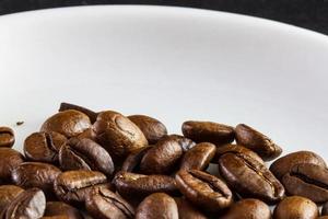 Makro von Kaffeebohnen in einer weißen Kaffeetasse
