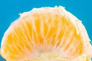 Scheibe der einzelnen frischen Mandarine auf blauem Hintergrund