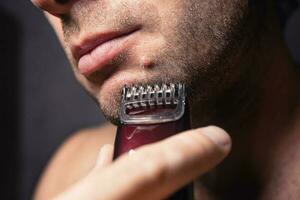 ein elektrisch Rasierapparat erlaubt Sie zu sicher rasieren Ihre Gesicht in der Nähe von ein Maulwurf foto