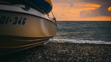 Boot auf das Strand im Stille gegen das Hintergrund von das Meer Sonnenuntergang - - rot Gelb Sonne Über das Horizont foto