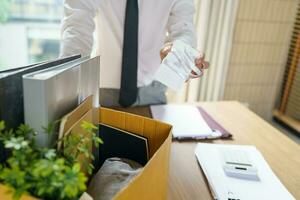 Verlassen Job Geschäft Mann Senden Rücktritt Brief und Verpackung Zeug zurücktreten drücken oder Tragen Geschäft Karton Box im Büro. Veränderung von Job oder gefeuert von Unternehmen. foto