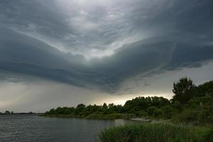 dramatische Landschaft mit Gewitterwolken über dem See foto