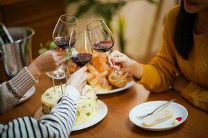 heiter freunde genießen Zuhause Geburtstag Urlaub Party. asiatisch freunde Jubel Trinken rot Wein feiern Weihnachten oder Neu Jahr Party foto