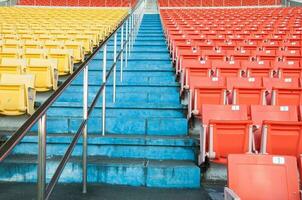 leeren Orange und Gelb Sitze beim Stadion, Reihen Gehweg von Sitz auf ein Fußball Stadion foto