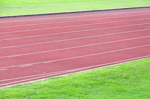 Laufen Spur und Grün Gras, direkt Leichtathletik Laufen Spur beim Sport Stadion foto