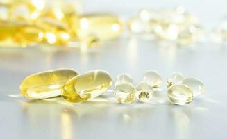 Vitamin d Gelb Ergänzung Gel Kapseln, Fisch Öl Omega 3 auf Weiß Hintergrund, Makro Schuss foto