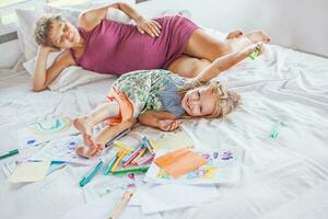 Mutter spielen und Zeichnung mit ihr Baby Tochter foto