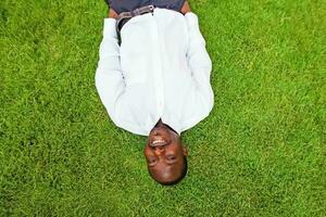 schwarz Mann Lügen Nieder auf ein Gras foto