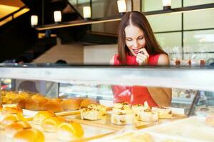 Frau wählen Bäckerei Artikel im ein Geschäft foto