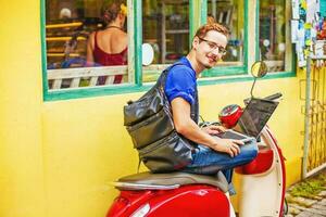 Mann mit Laptop auf Motorrad foto