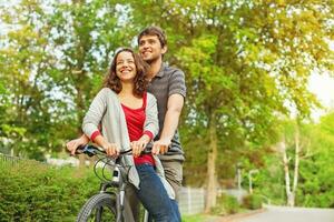 Menschen im Liebe - - Reiten zusammen auf das gleich Fahrrad foto