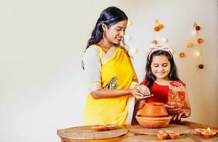 schön indisch Mutter und Tochter beten und tun Puja mit Kalasha auf navratri Tage, wenig Mädchen suchen beim Kamera foto