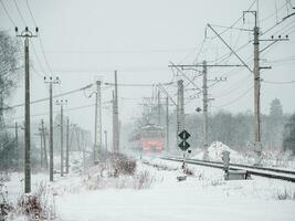 das Zug ist im Bewegung auf ein schneebedeckt Winter Tag. foto