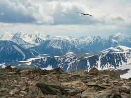 dramatisch Antenne Aussicht zu groß Schnee Berg Angebot unter veränderbar regnerisch wolkig Himmel. hell atmosphärisch alpin Landschaft mit hoch schneebedeckt Berg Gipfel im niedrig Wolken. foto