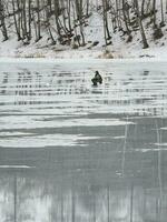 gefährlich Angeln auf nass Frühling Eis. Fischer auf nass schmelzen Eis foto