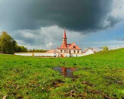 Frühling Landschaft mit nass Grün Rasen in der Nähe von das Weiß alt maltesisch Palast. groß Pfütze im das Frühling. sonnig Frühling Aussicht von das uralt maltesisch Palast im Gatschina Park, Russland. foto